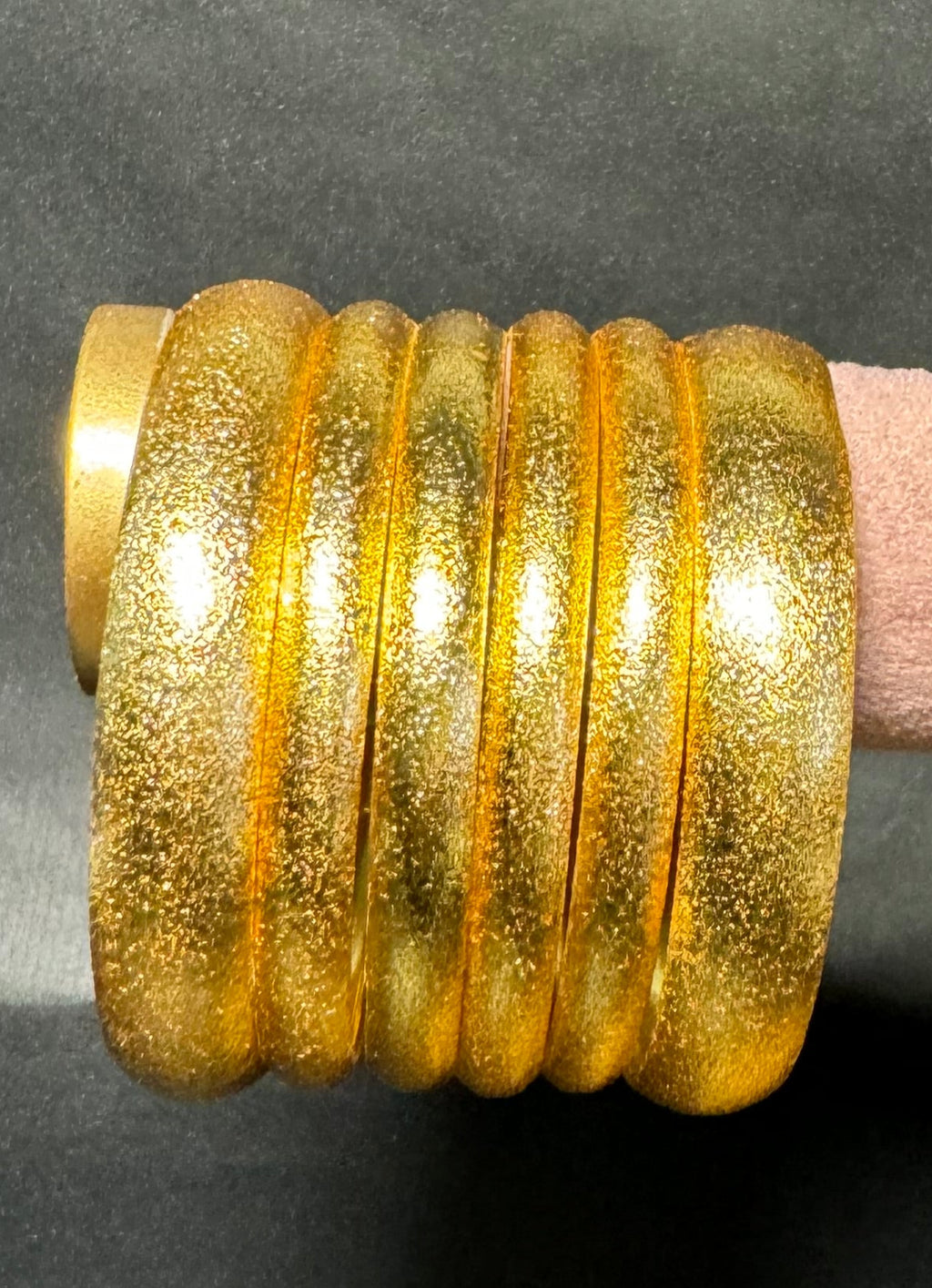 Decorative wall sconce with gold finish on a dark gray background