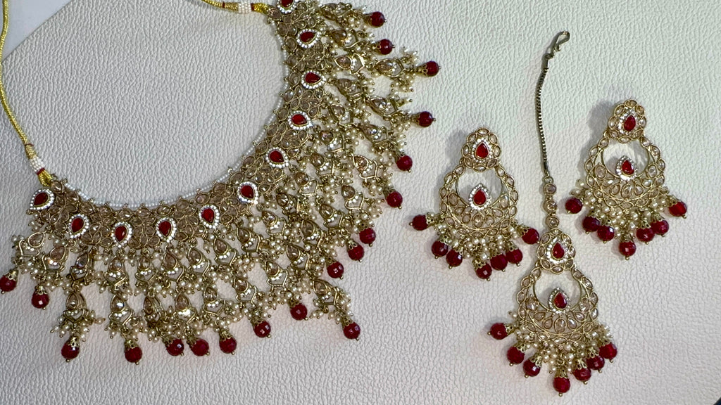Ornate necklace with red stones on a white background